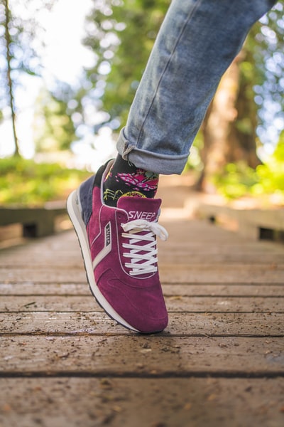 Dressed in blue denim jeans and the purple and white Nike sneakers
